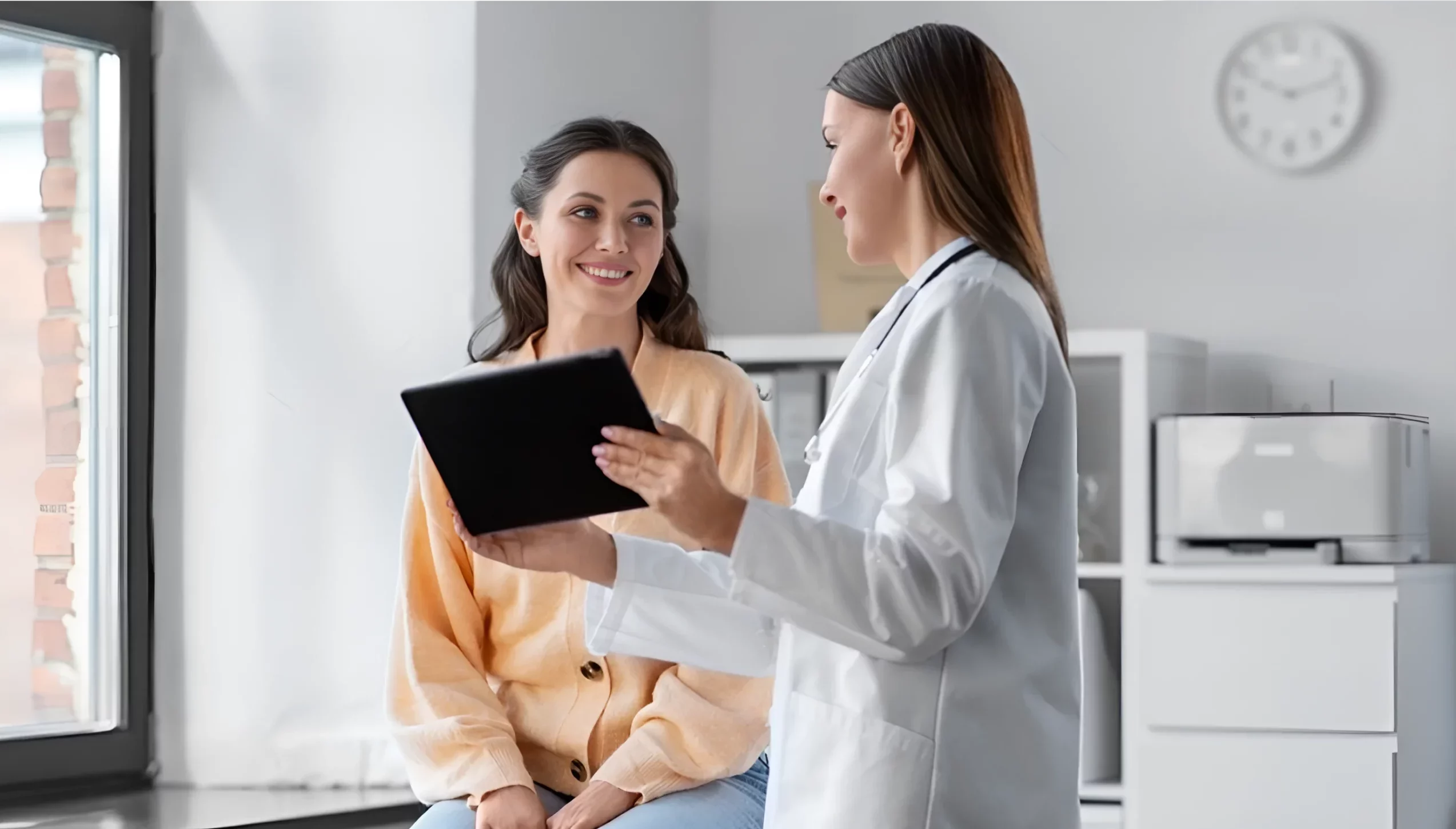 Smiling woman sitting in consultation with doctor