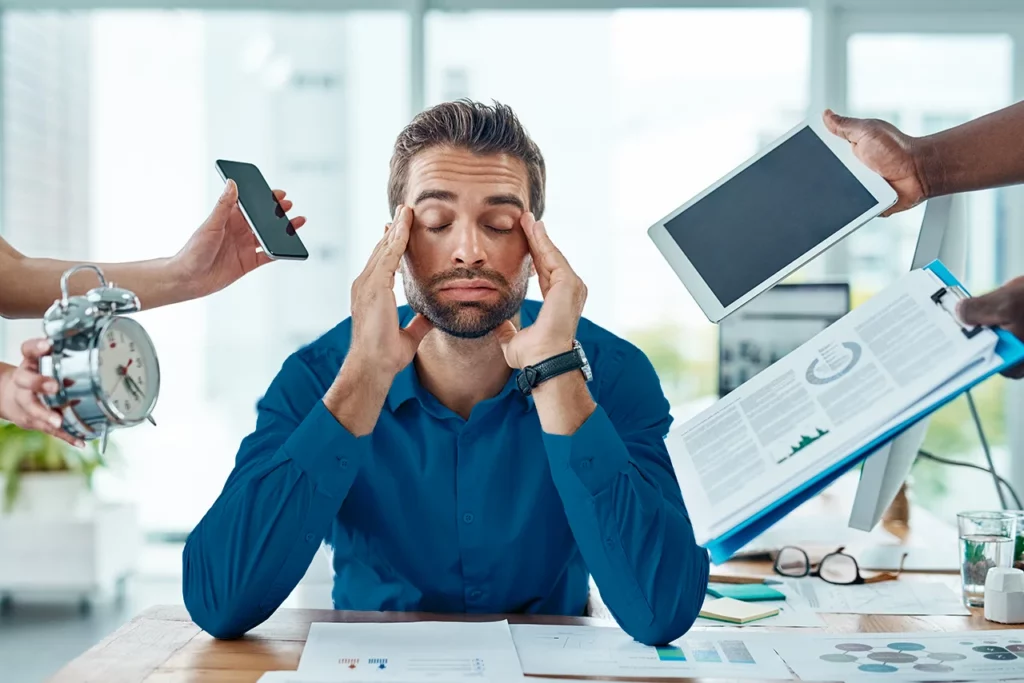 Hombre que percibe varias causas que desencadenan diversos tipos de estrés en su día a día.