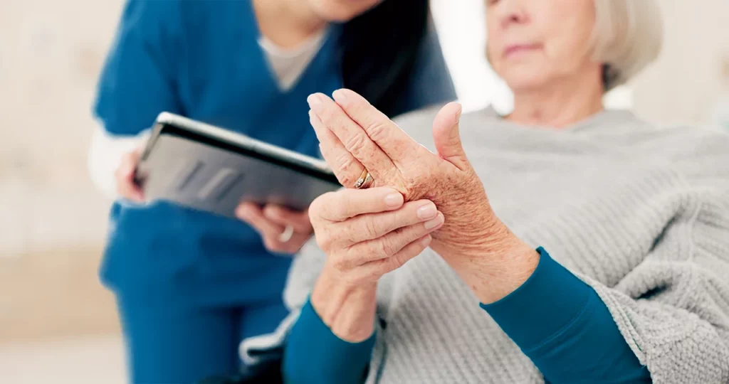 Doctora revisando a una paciente que le explica los que siente por su artritis en las manos.